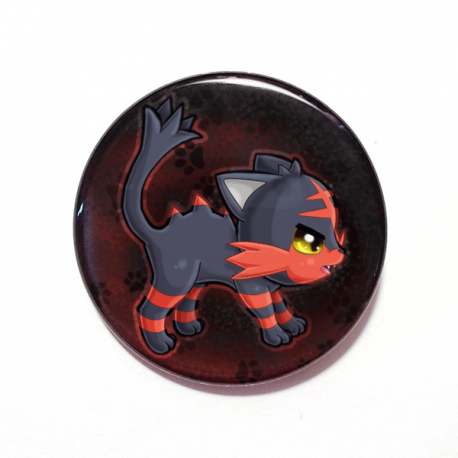 A cute chibi version of Litten from Pokemon drawn by Camie M. Anderson on a handmade button