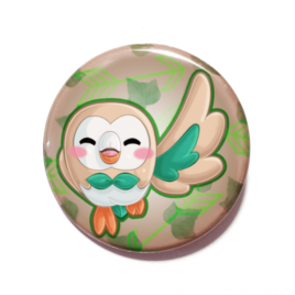 A cute chibi drawing of Rowlet from Pokemon on a handmade button by Camie M. Anderson
