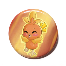 A cute chibi version of Torchic from Pokemon drawn by Camie M. Anderson on a handmade button