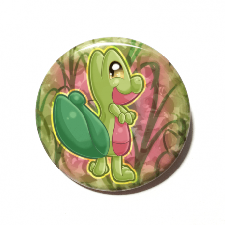 A cute chibi version of Treecko from Pokemon drawn by Camie M. Anderson on a handmade button